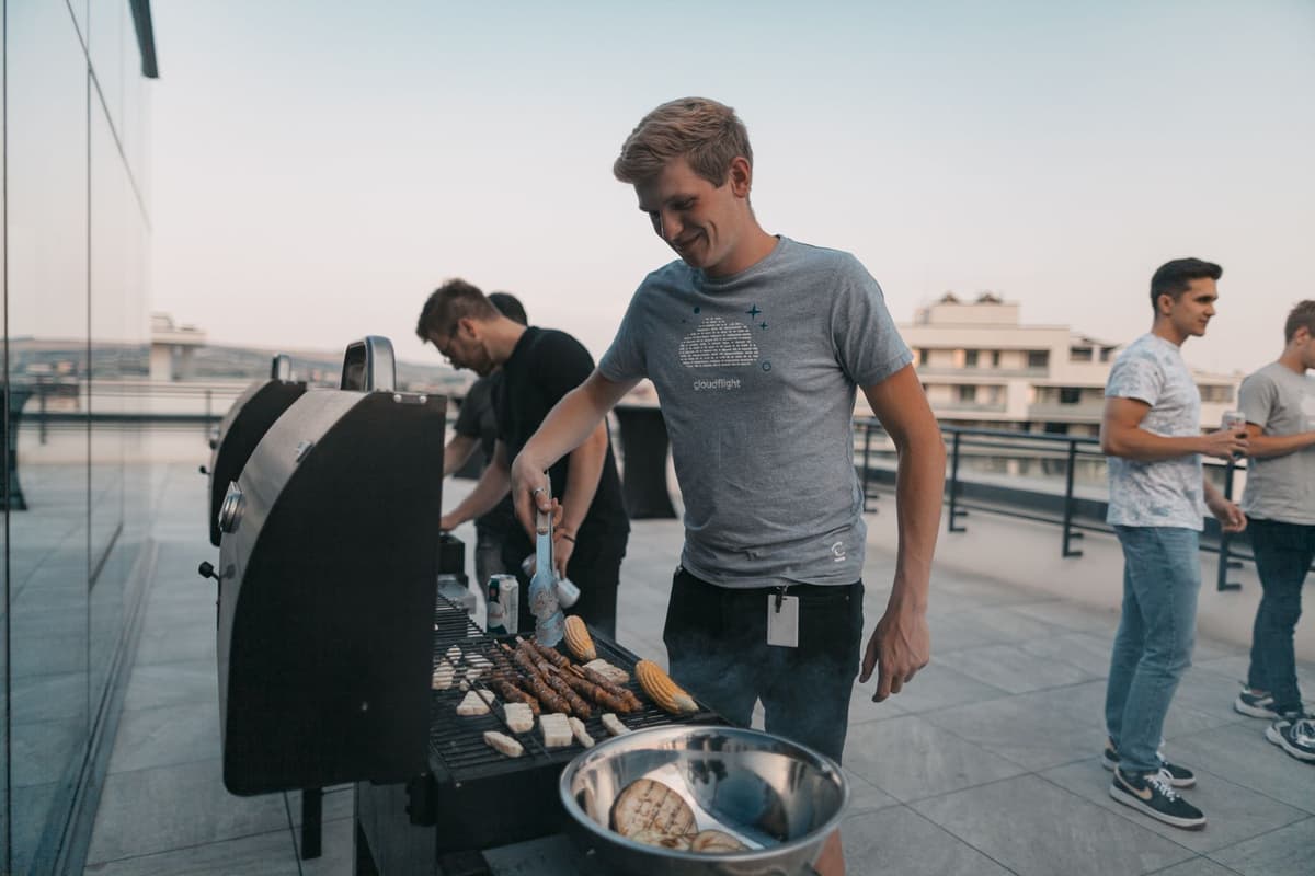 Ein Cloudflighter grillt Fleisch und Gemüse auf einem Grill auf unserer Dachterrasse in Cluj